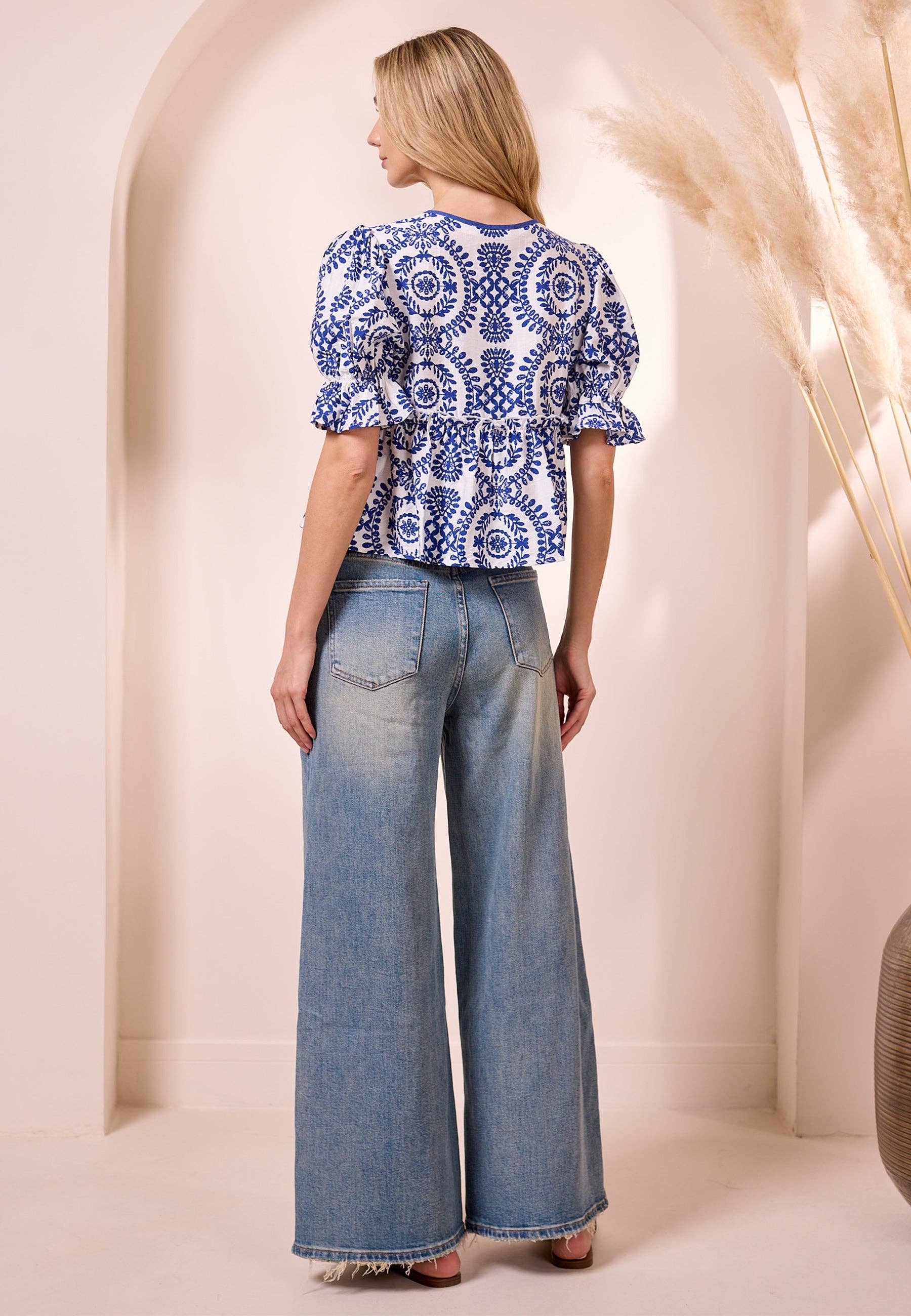 White peplum top with blue embroidery print